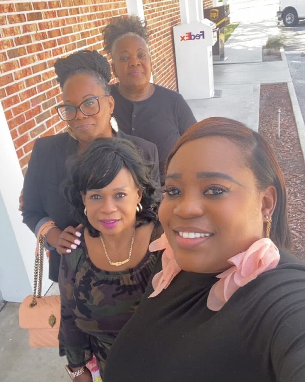 Four women from the ministry smile together outside.